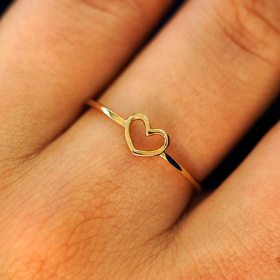 Close up view of a model's fingers wearing a 14k yellow gold Heart Ring