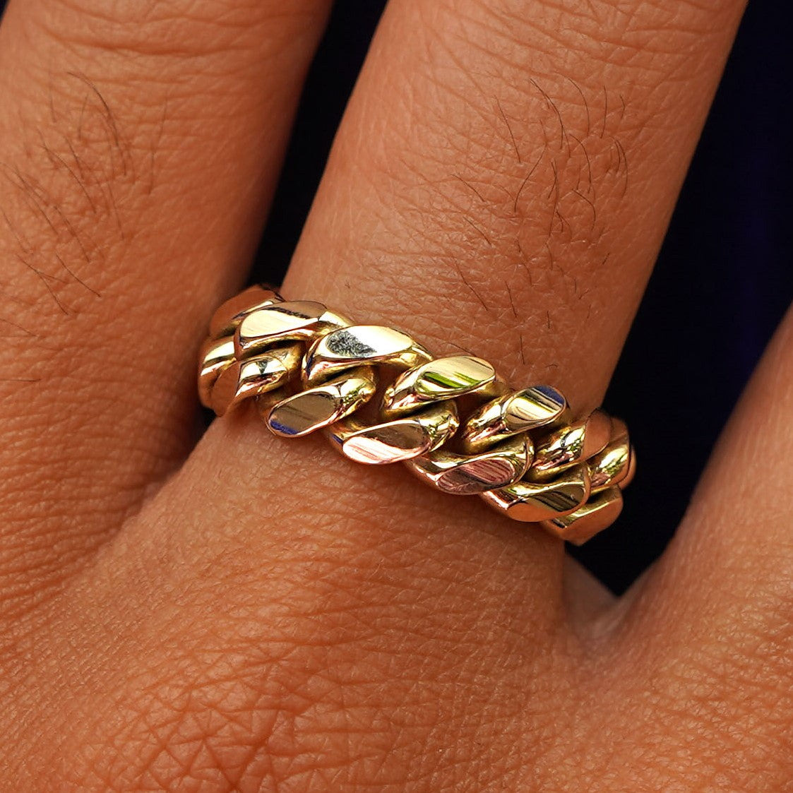 Close up view of a model's hand wearing a yellow gold Miami Cuban Ring