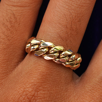 Close up view of a model's hand wearing a yellow gold Miami Cuban Ring