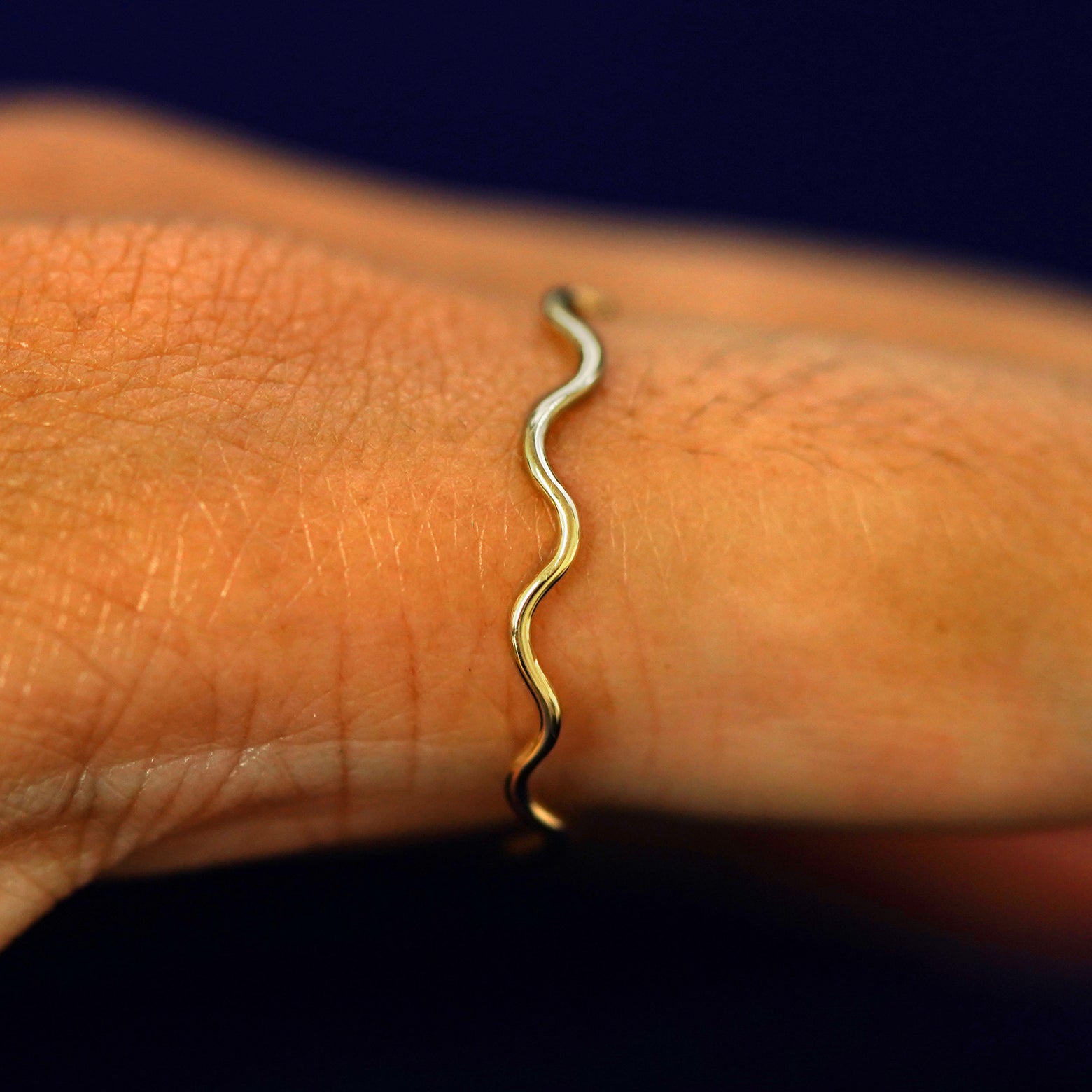 Side view of a Wave Ring on a model's finger