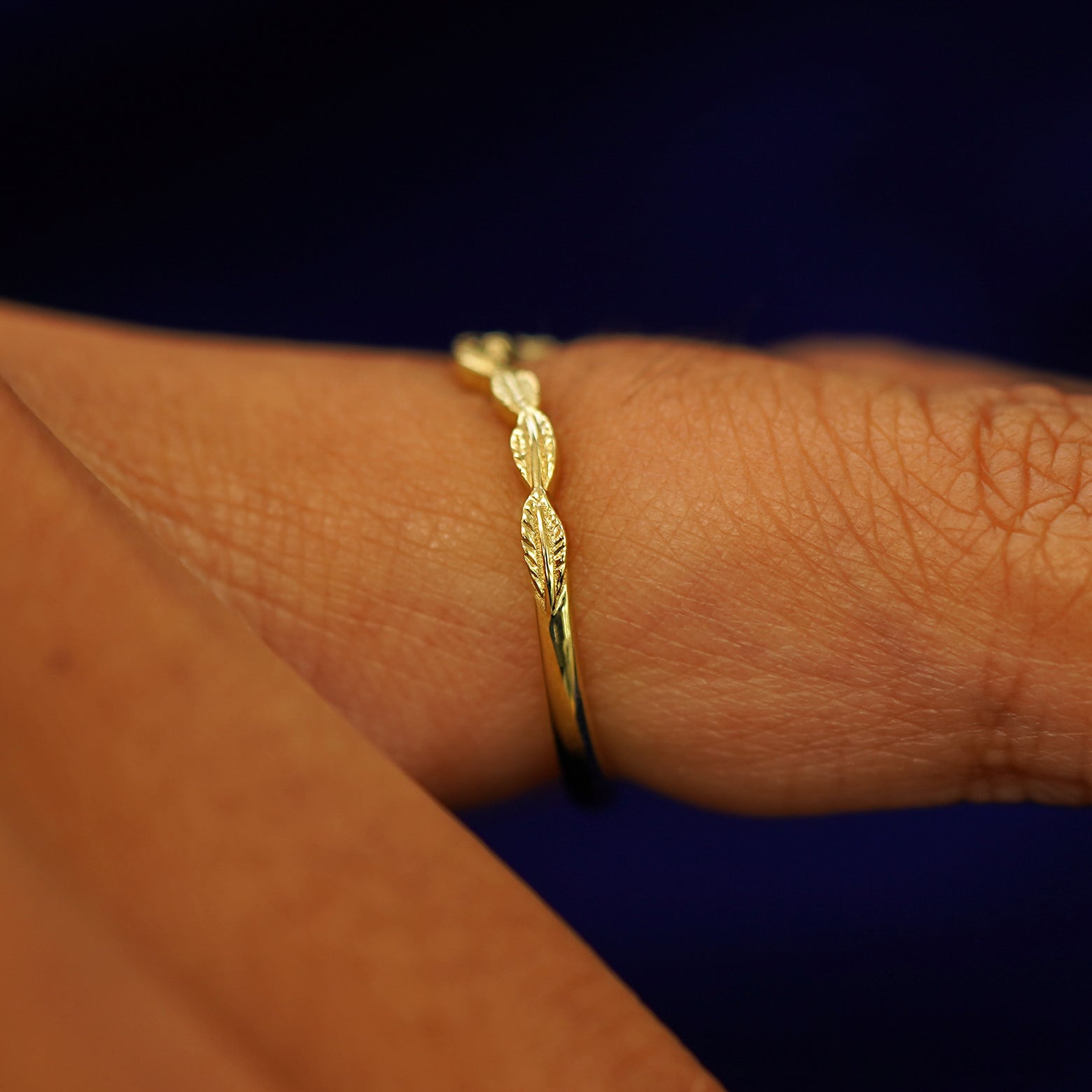 Side view of a Chevron Leaves Band on a model's finger to show details