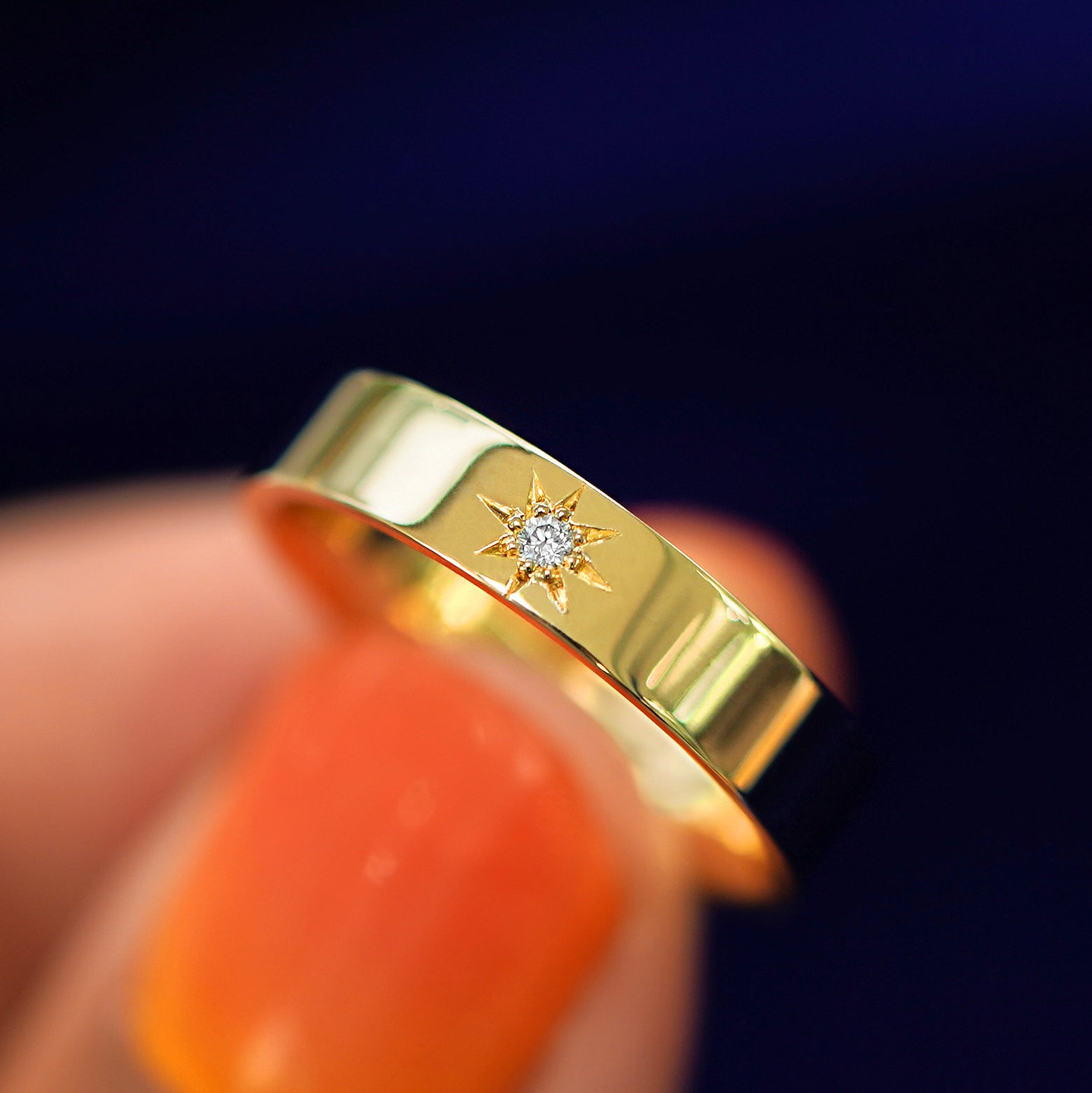 A model holding a Engraved Star Diamond Band tilted to show the details of the diamonds