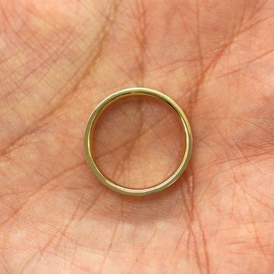 A yellow gold Engraved Star Diamond Band in a model's hand showing the thickness of the band