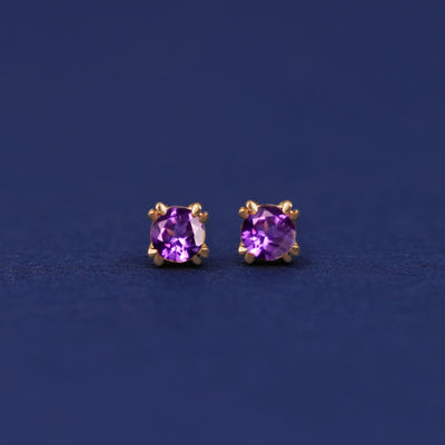 A pair of 14 karat gold studs earrings with 3 millimeter round Amethyst gemstones