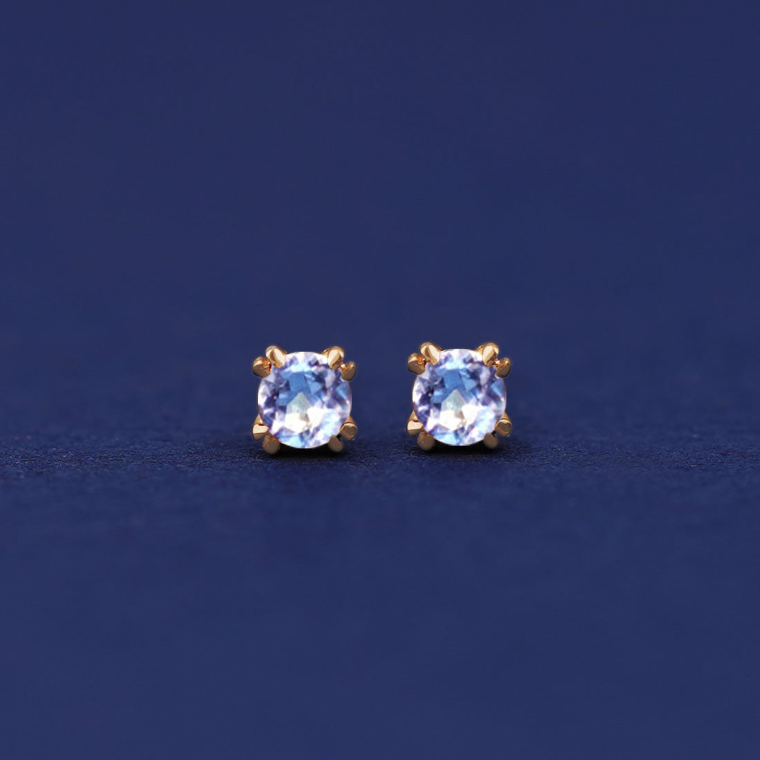 A pair of 14 karat gold studs earrings with 3 millimeter round Aquamarine gemstones