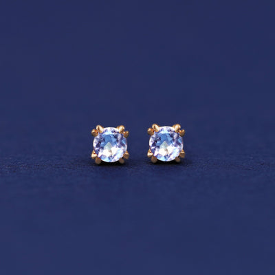 A pair of 14 karat gold studs earrings with 3 millimeter round Aquamarine gemstones