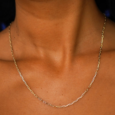 Close up view of a model's neck wearing a long solid yellow gold Butch Chain