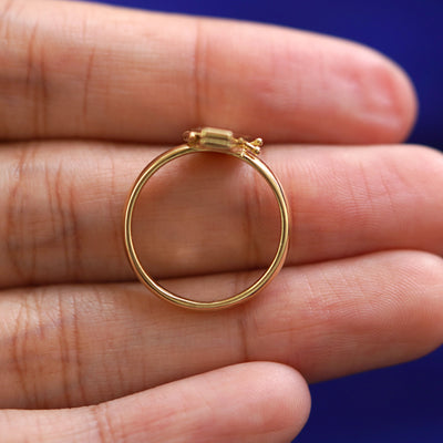 A yellow gold Coffin Ring in a model's hand showing the thickness of the band