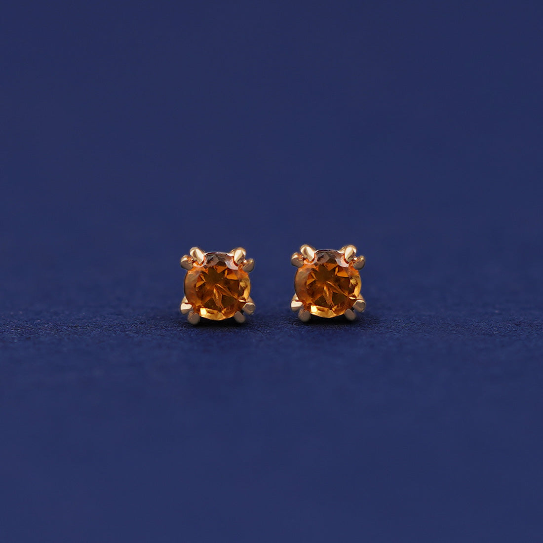 A pair of 14 karat gold studs earrings with 3 millimeter round Citrine gemstones