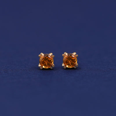 A pair of 14 karat gold studs earrings with 3 millimeter round Citrine gemstones