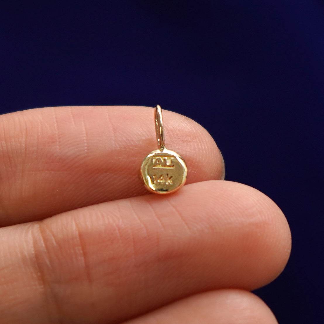 Back side view of a solid gold coffee cup charm to show the AU and 14k stamps