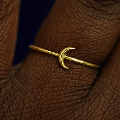 Close up view of a model's fingers wearing a 14k yellow gold Moon Ring