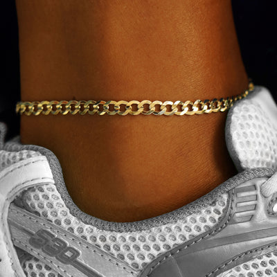 A model's ankle wearing a 14k yellow gold Curb Anklet