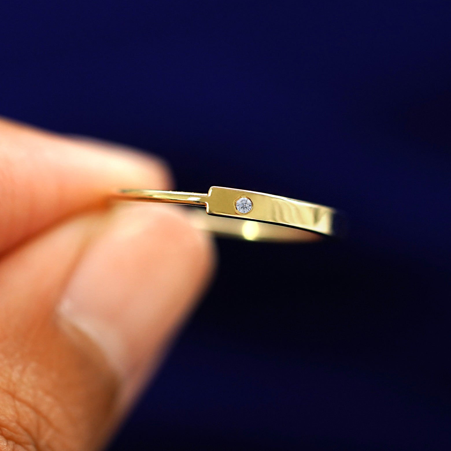 A model holding a Diamond Gemstone Bar Ring between their fingers to show detail of the gem