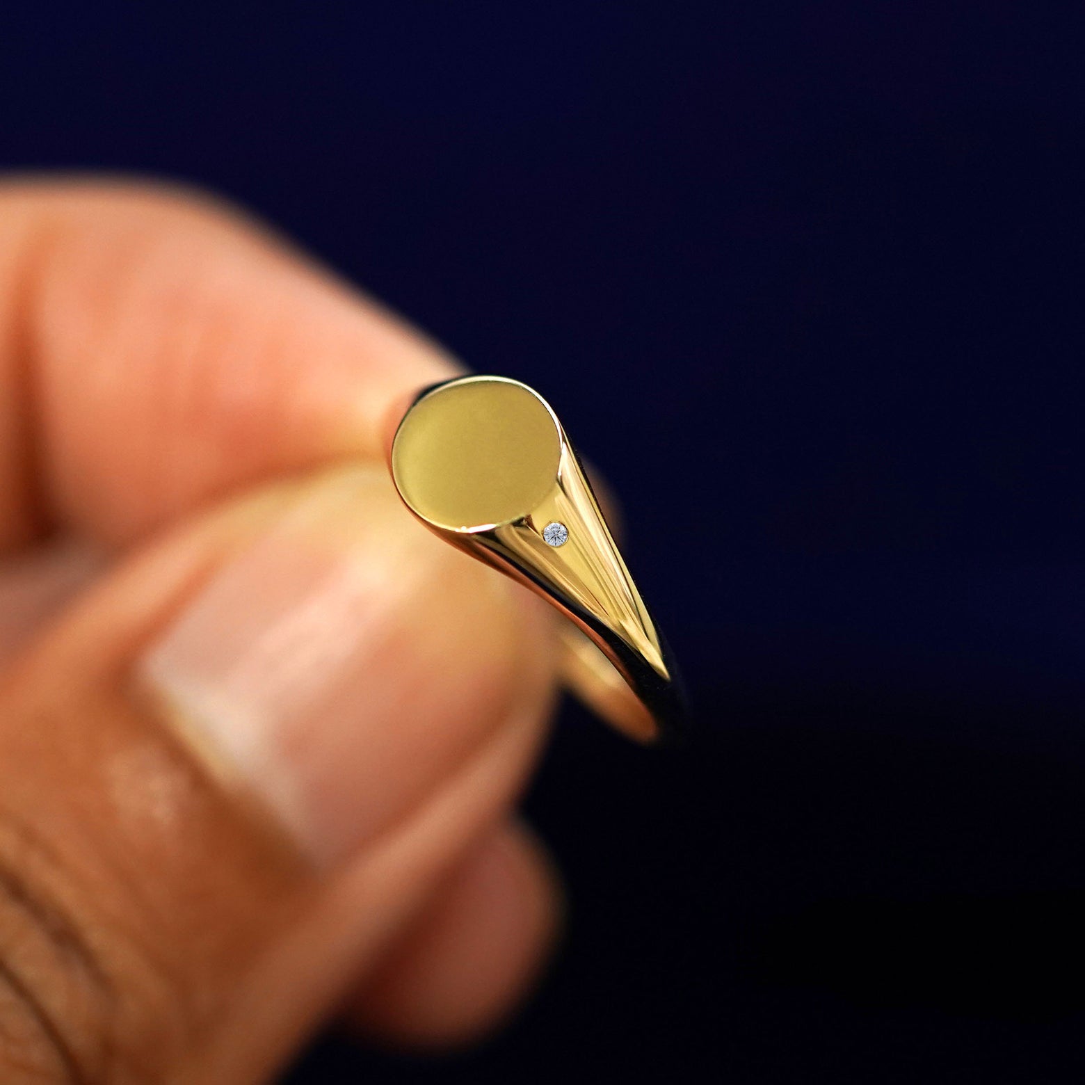 A model holding a Diamond Signet Ring tilted to show the side of the ring