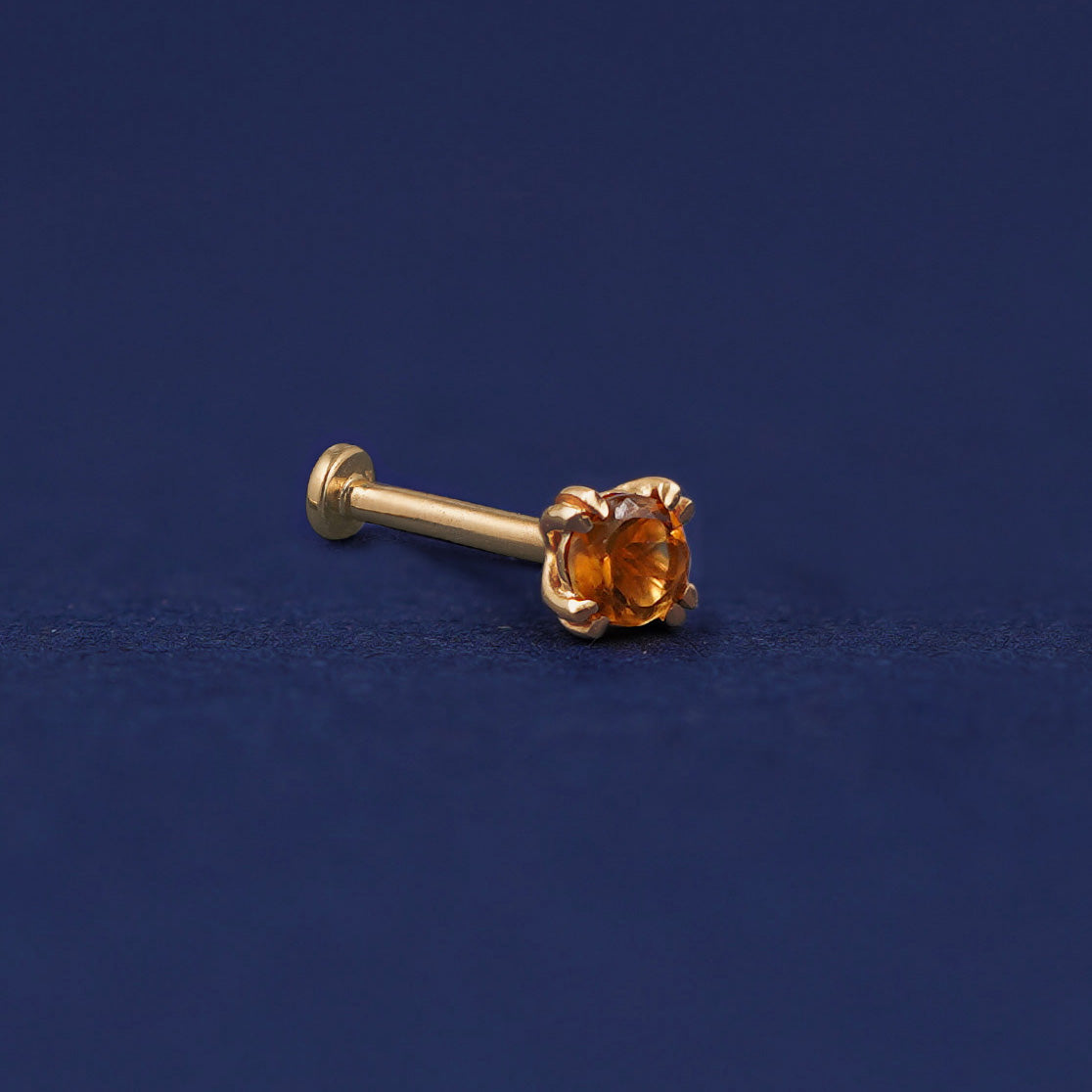 A 14 karat solid gold Citrine Flat Back Earring on a dark blue background