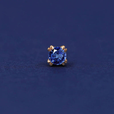 Front facing view of a 14k yellow gold Sapphire Flat Back Earring on a dark blue background