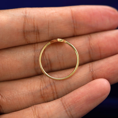A yellow gold Enamel Heart Ring in a model's hand showing the thickness of the band