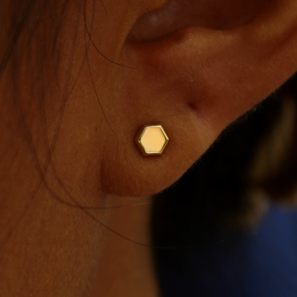 Close up view of a model's ear wearing a yellow gold Hexagon Earring