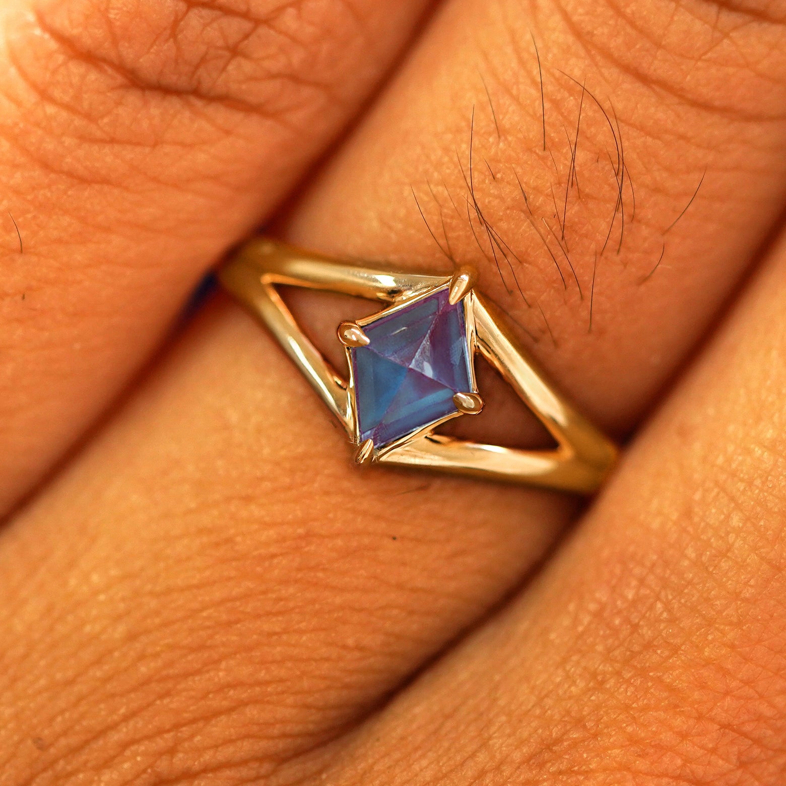 Close up view of a model's fingers wearing a 14k yellow gold Alexandrite Kite Ring