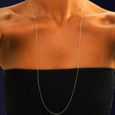 A model wearing a 14k solid yellow gold Cable Infinity Necklace