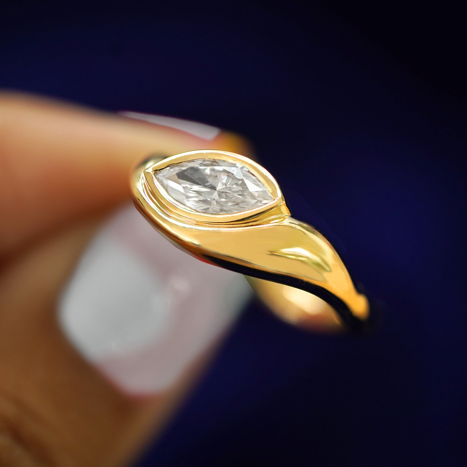 A model holding a Marquise Lab Diamond Melted Ring tilted to show the side of the band