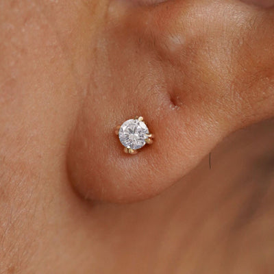 Close up view of a model's ear wearing a 14k yellow gold Moissanite Earring