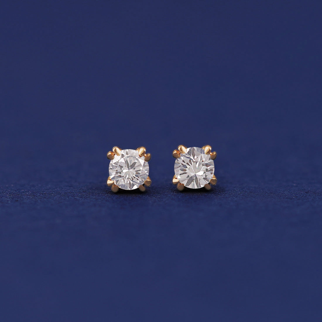 A pair of 14 karat gold studs earrings with 3 millimeter round Moissanite gemstones
