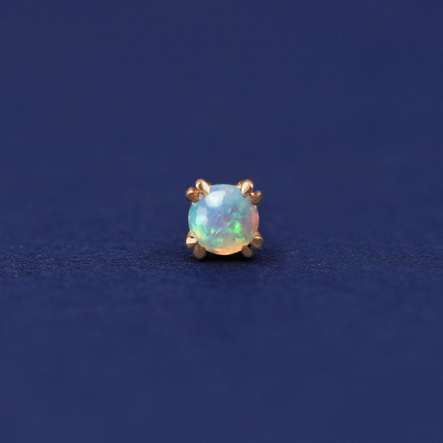 A 14 karat gold stud earring with 3 millimeter round Opal gemstones