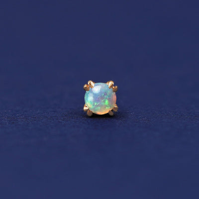 A 14 karat gold stud earring with 3 millimeter round Opal gemstones