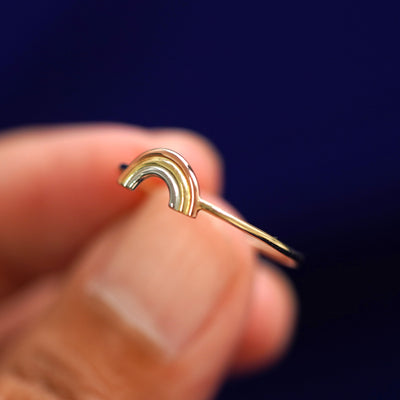 A model holding a Rainbow Ring tilted to show the side of the ring