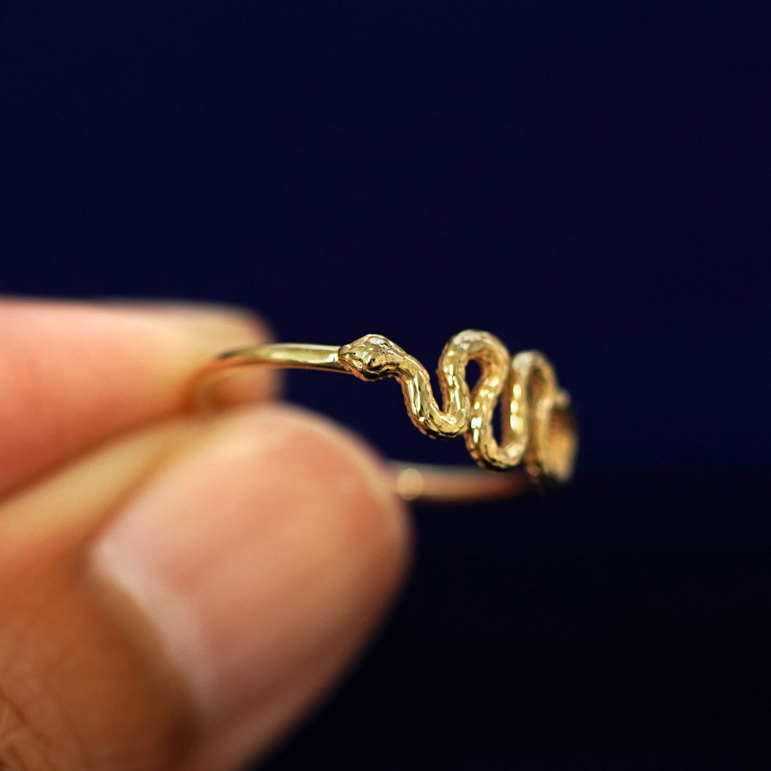 A model holding a Snake Ring tilted to show the details of the snake's head
