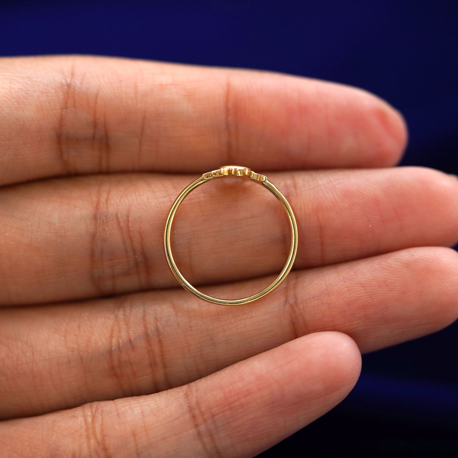 A yellow gold Sun Ring in a model's hand showing the thickness of the band