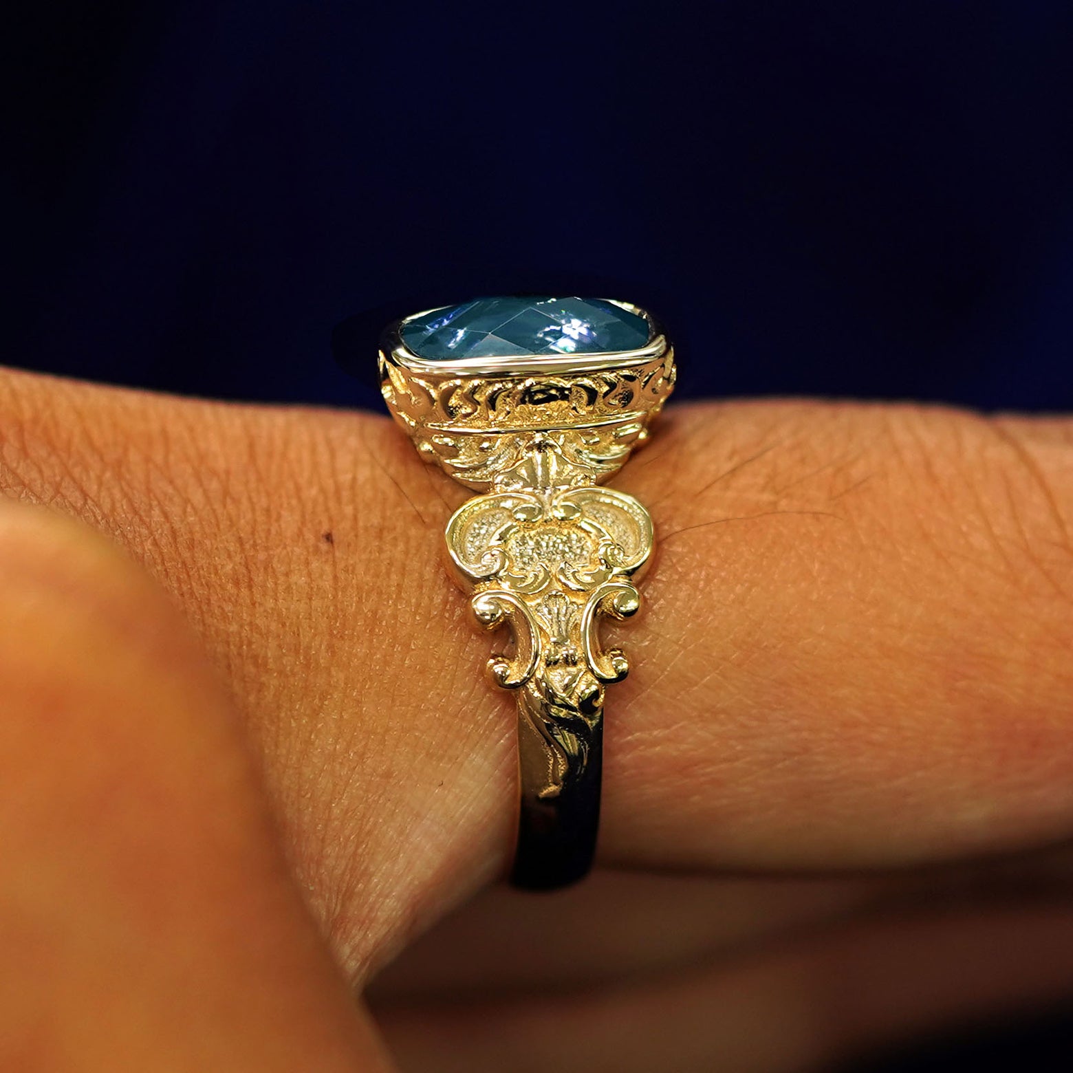 Side view of a 14k gold London blue topaz Royalty Ring on a model's finger