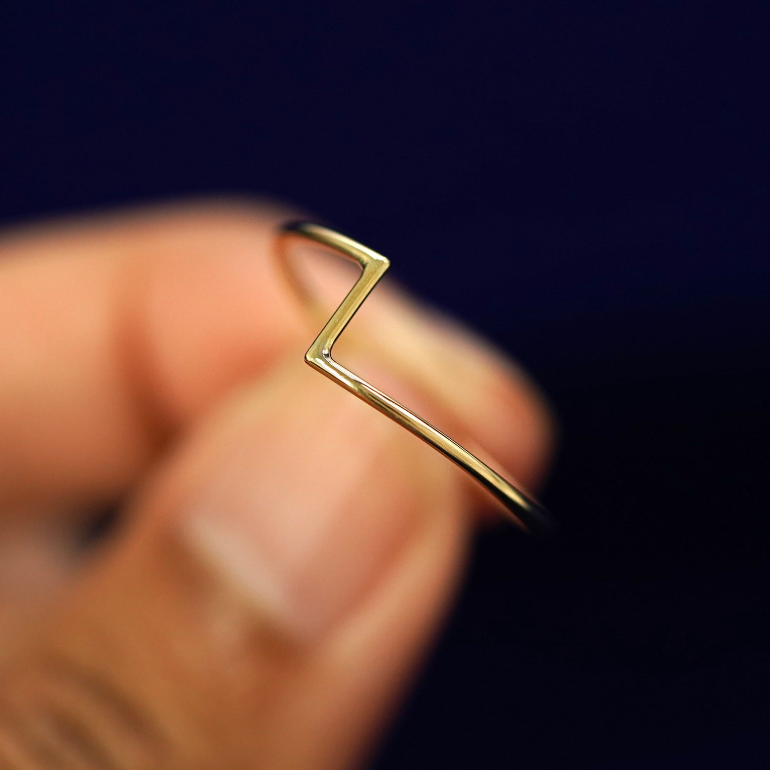 A model holding a Zig Zag Ring tilted to show the side of the ring