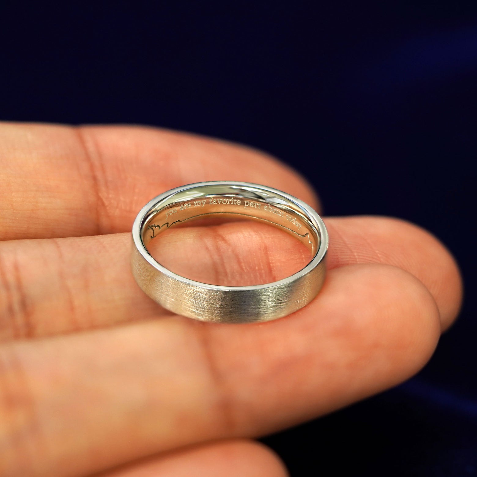 A Matte Industrial Band in a model's hand engraved with the words You Are My Favorite Part About Today