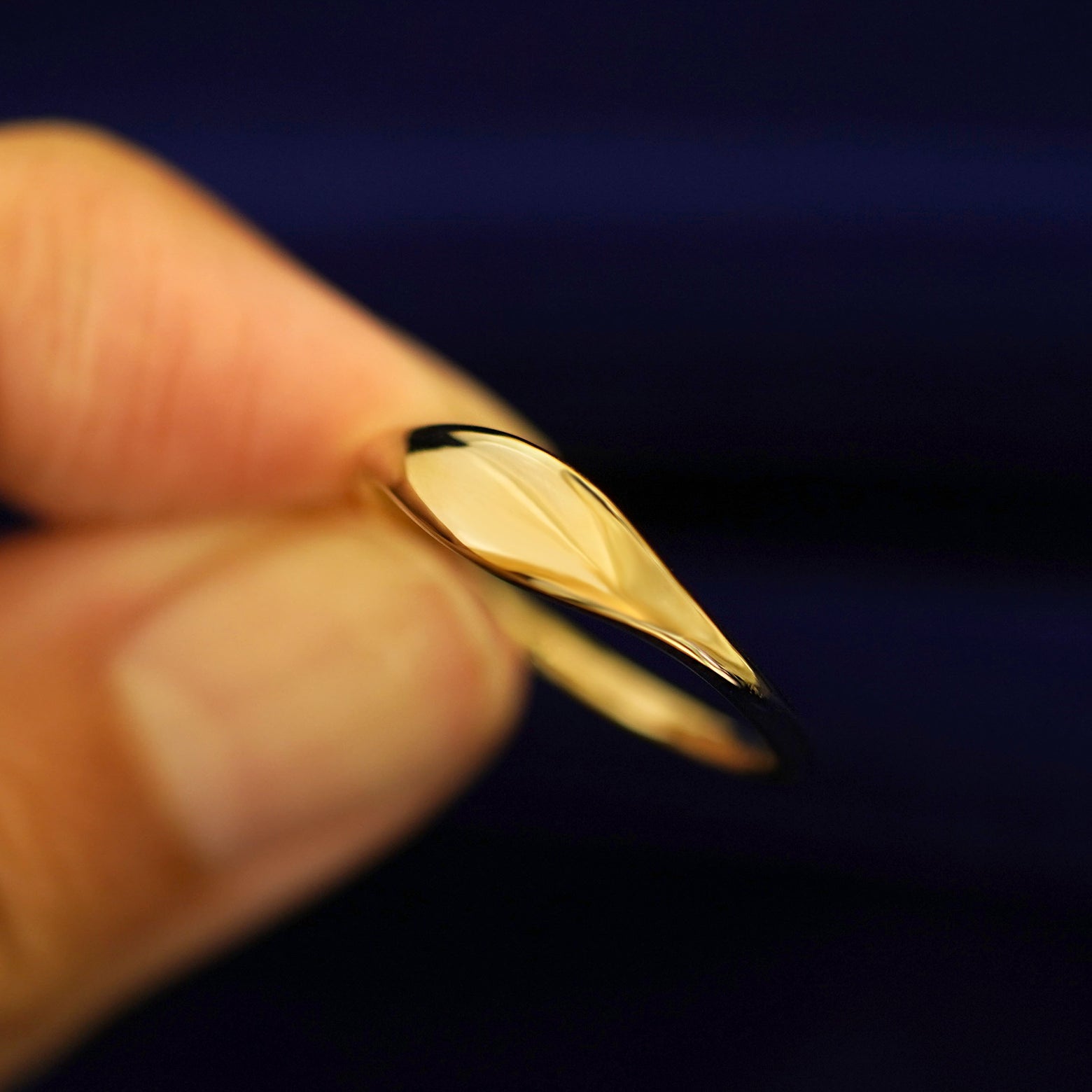 A model holding a Puffy Elongated Signet Ring tilted to show the detail of the top of the ring