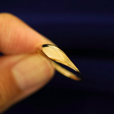 A model holding a Puffy Elongated Signet Ring tilted to show the detail of the top of the ring