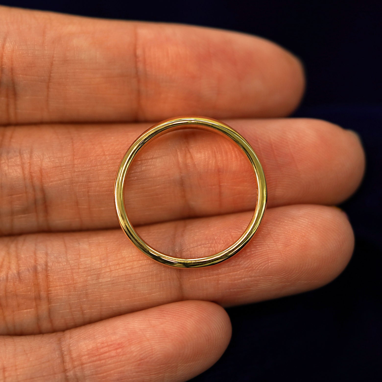 A yellow gold Puffy Elongated Signet Ring in a model's hand showing the thickness of the band