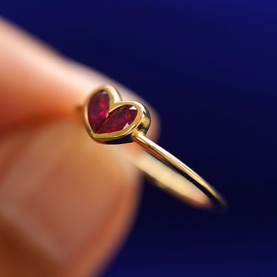 A model holding a Ruby Heart Ring tilted to show the side of the ring