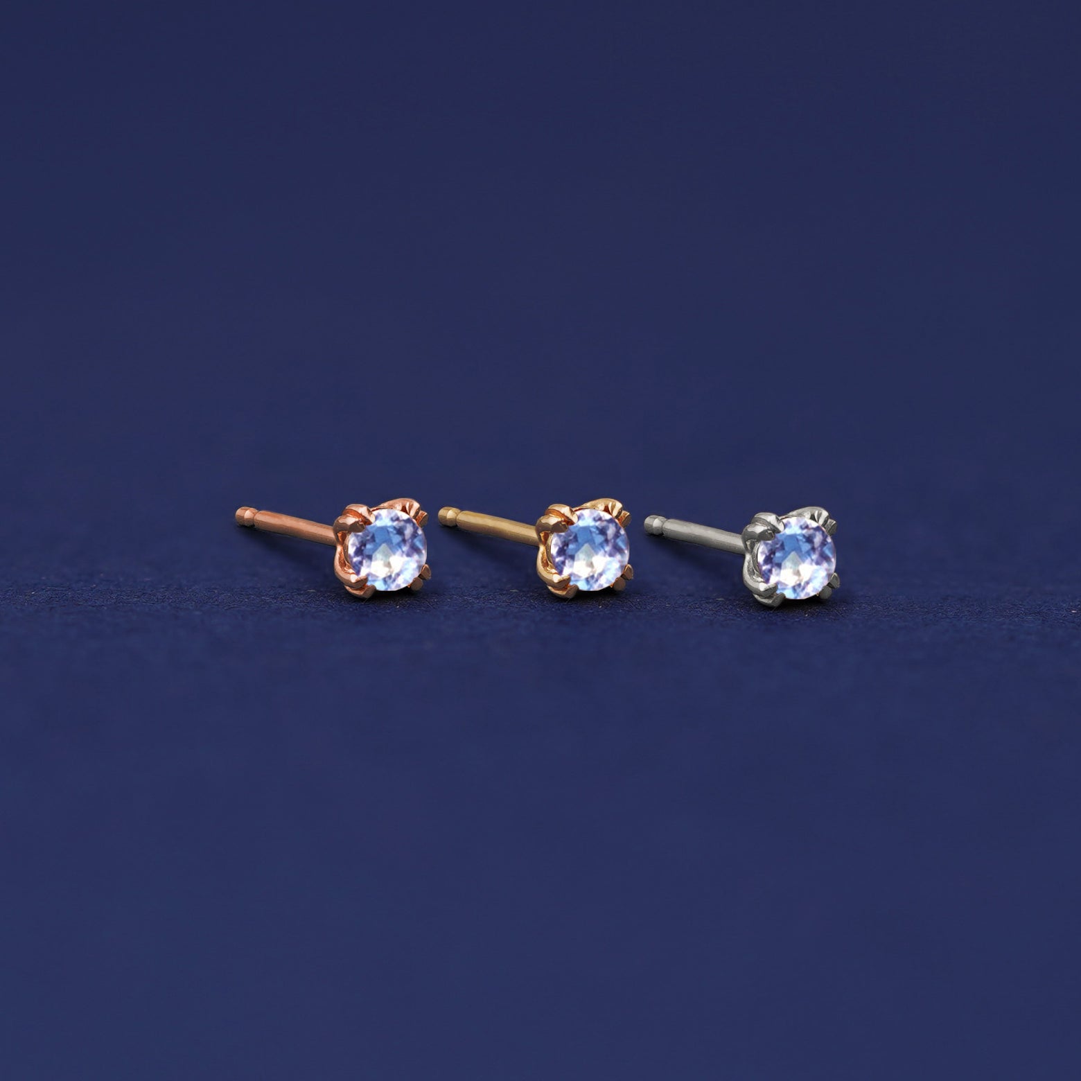 Three versions of the Aquamarine Earring shown in options of rose, yellow, and white gold