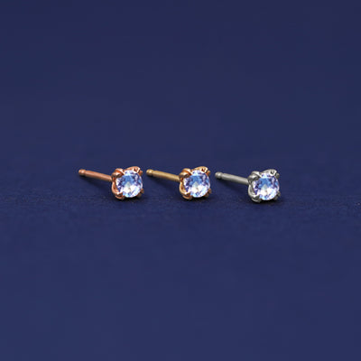 Three versions of the Aquamarine Earring shown in options of rose, yellow, and white gold