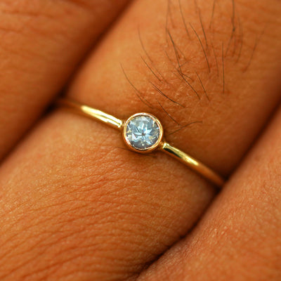 Close up view of a model's fingers wearing a 14k yellow gold Aquamarine Ring
