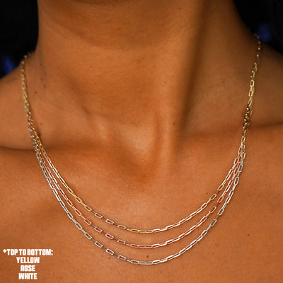 Close up view of a model's neck wearing three versions of the Butch Chain in yellow, white, and rose gold