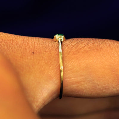 Side view of an Emerald Ring on a model's finger