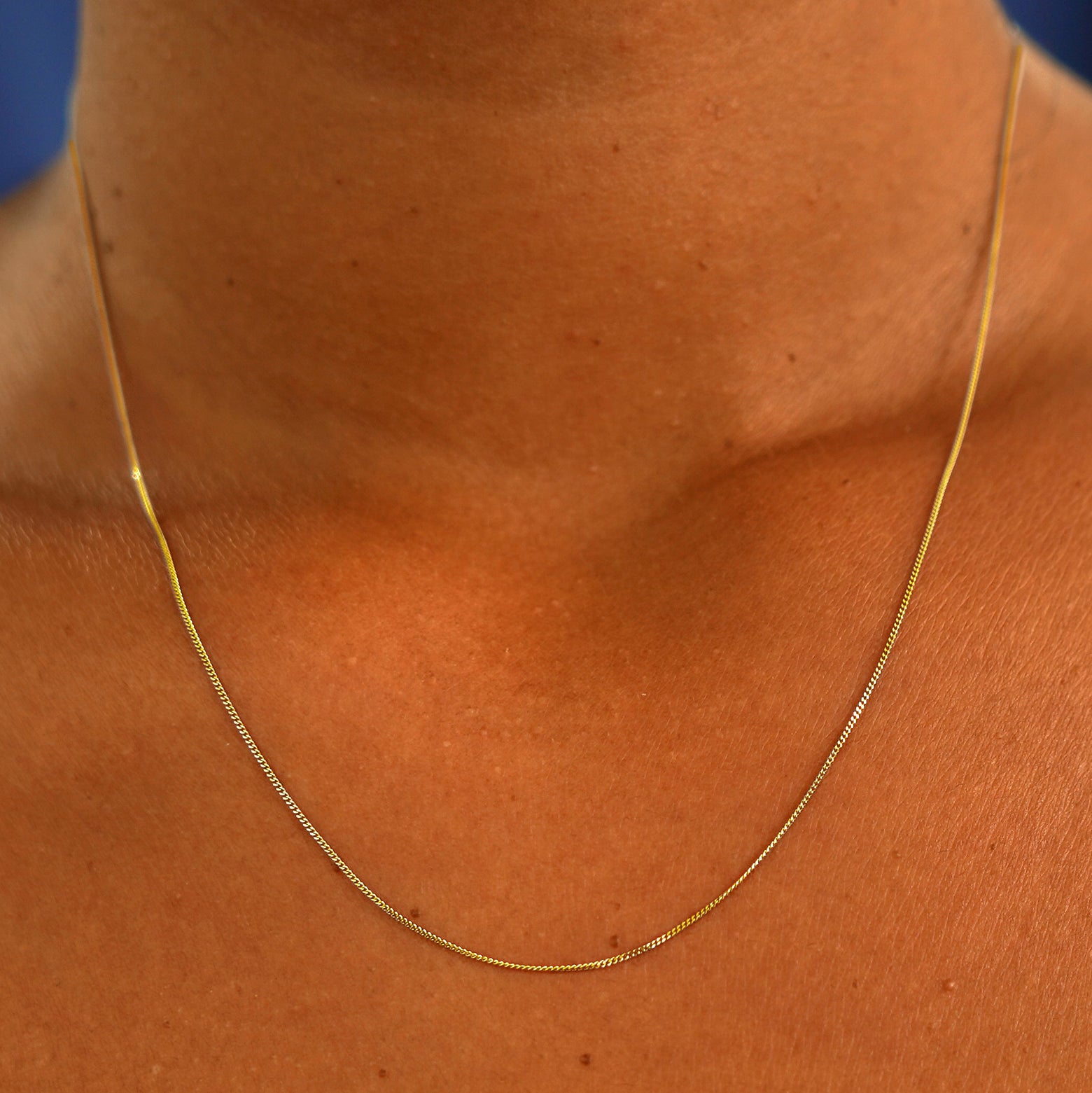 A model's neck wearing a 14k yellow gold Essential Chain