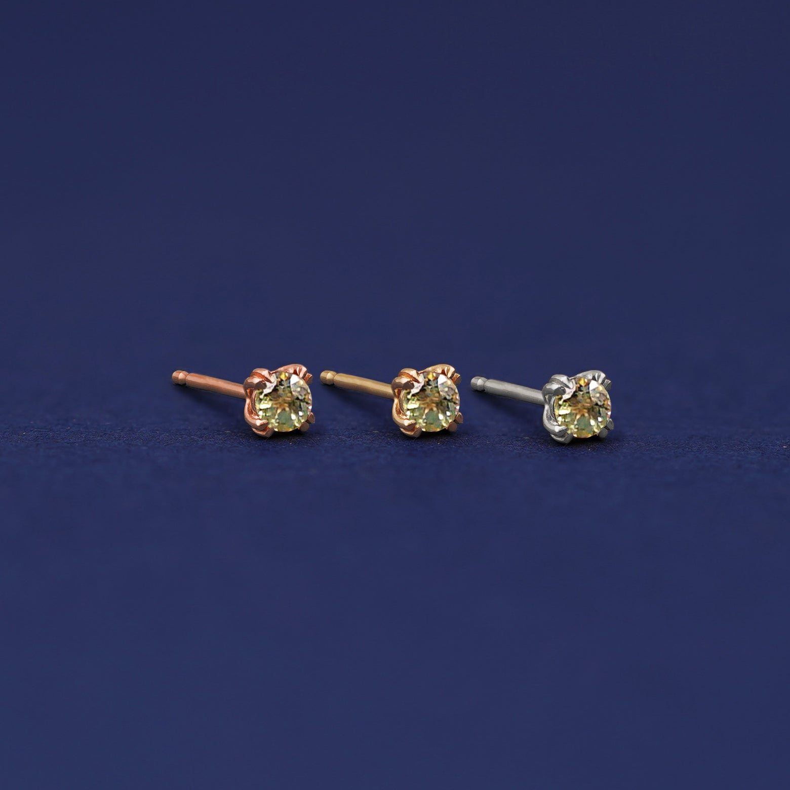 Three versions of the Peridot Earring shown in options of rose, yellow, and white gold