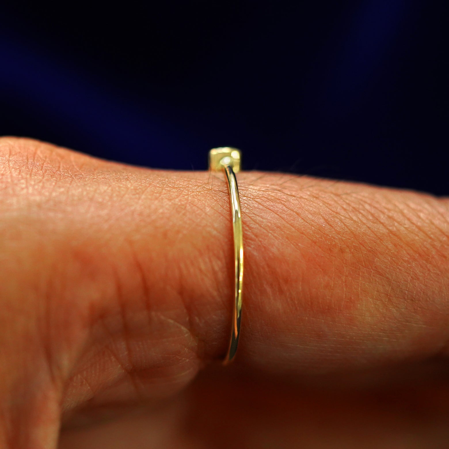 Side view of a Peridot Ring on a model's finger