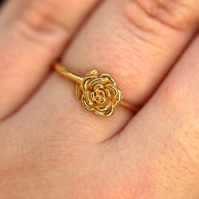 Close up view of a model's fingers wearing a 14k yellow gold Rose Ring