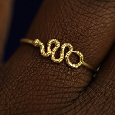 Close up view of a model's fingers wearing a 14k yellow gold Snake Ring